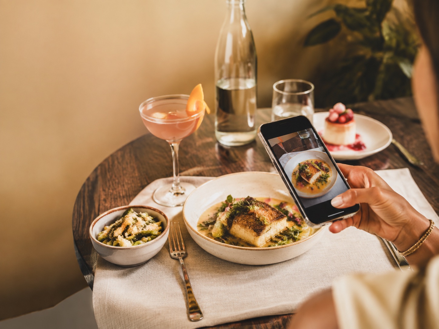 A creator recording a restaurant video at the table